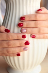 Woman with stylish color nails holding vase, closeup