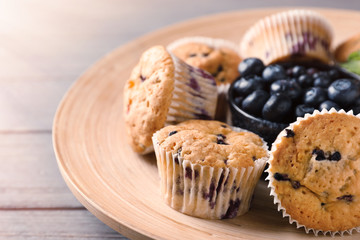 Tasty blueberry muffins with fresh berries on plate, closeup