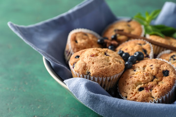 Tasty blueberry muffins in bowl on table, closeup