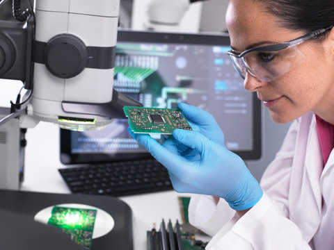 Engineer using 3D servo microscope to view dimensional accuracy of manufactured PCB assembly
