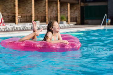 Teenage girl on air mattress at pool