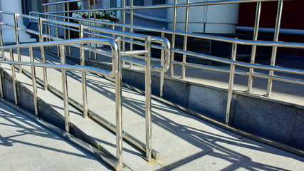 ramp with stainless steel fencing and chrome-plated metal structures for disabled wheelchair users, trolleys with cargo and gods