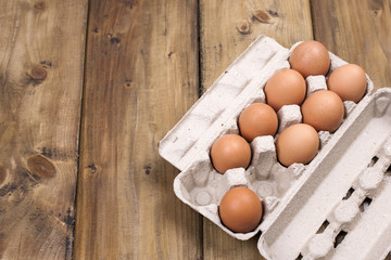 Preparation of homemade cakes on a wooden background. Ingredients and accessories for the kitchen and at home. Eggs in a box and space for text. Top view
