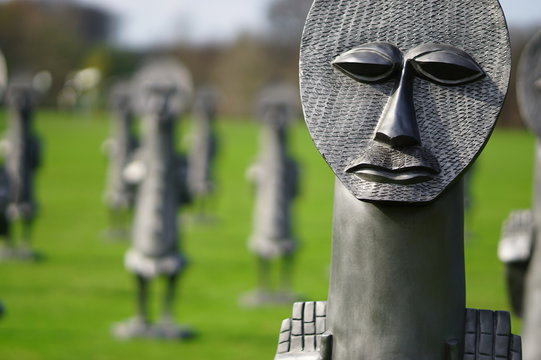 Statue or sculpture of weird faces in a garden, photo taken in Yorkshire Sculpture Park, Wakefield, England, United Kingdom