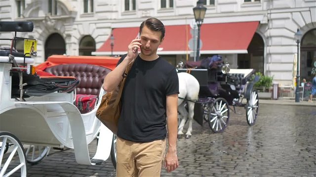 Tourist man enjoying a stroll through Vienna and looking at the beautiful horses in the carriage