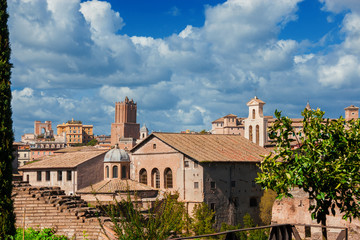 Fototapeta na wymiar Rome historic center old skyline above Imperial Fora with medieval Tower of Militia, old churches and clouds, seen from Palatine Hill