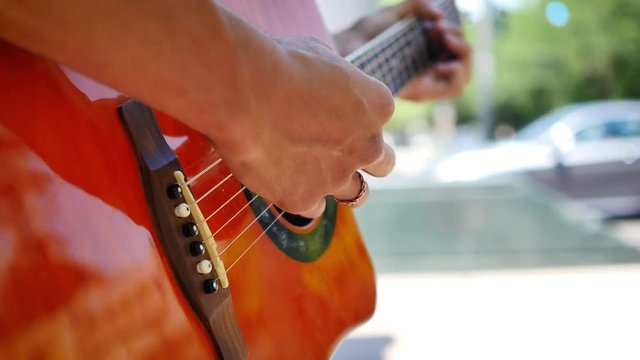Street performer rapidly playing guitar