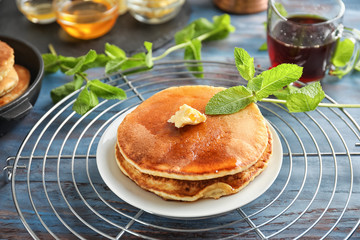 Cooling rack with tasty pancakes on wooden table