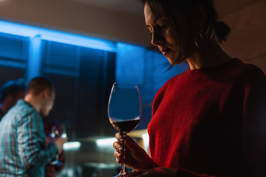 Woman drinking wine at party in apartment