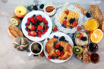 breakfast on table with waffles, croissants, coffe and juice.