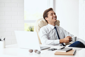 Young handsome businessman smiling in a modern office