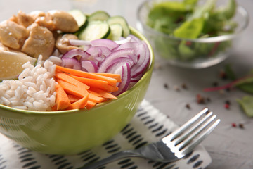 Bowl with tasty rice, vegetables and meat on table, closeup