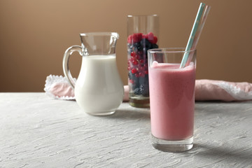 Glass with tasty raspberry milkshake on wooden table