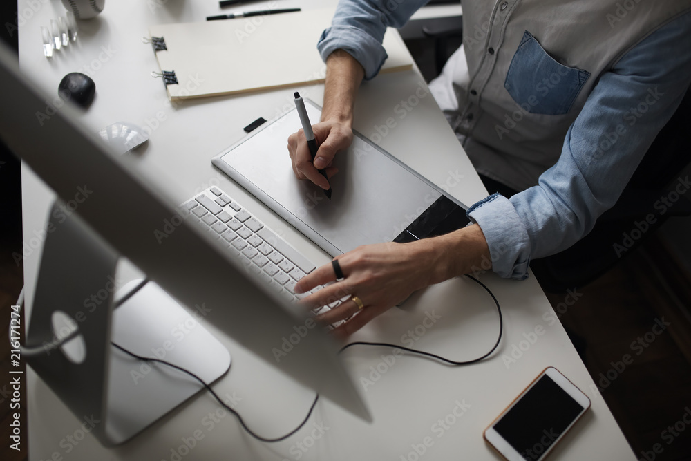 Aufkleber young male designer using graphics tablet while working with com