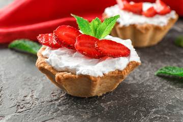 Tasty tartlet with strawberry on table