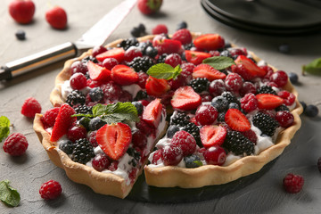 Delicious pie with ripe berries on table