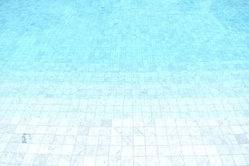 Background of a blue tiled pool with clear cool rippling water