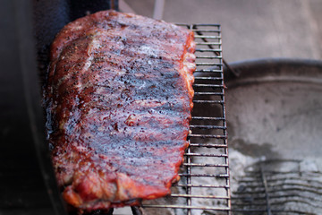 Rack of dry rub pork ribs on the BBQ grill.