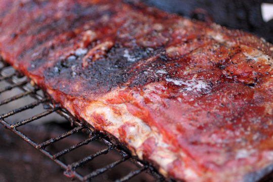 Rack of dry rub pork ribs on the BBQ grill.