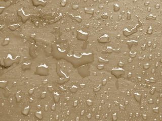 water drops on almond buff colored metallic surface