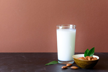 Almond milk with almond on a brown wooden table. Healthy eating concept.