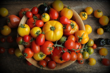 Wooden bowl with fresh vine ripened heirloom tomatoes from farmers market