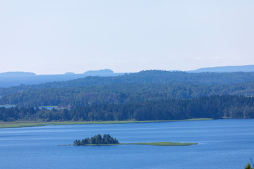 The the island in the Ladoga lake in Russia with the mountains and the forest on the skyline in the sunny summer day