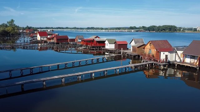Aerial panorama of traditional fishing houses line on the lake shore, Hungary.
