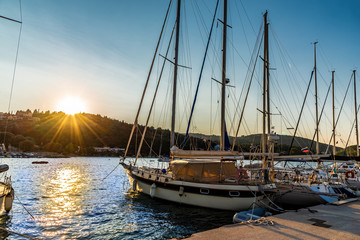 Beautiful sunset over Lefkada island in Greece. Sail boat on the harbor of Vasiliki port,