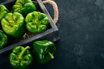 Fresh green pepper in a wooden box. Organic food. Top view. Free space for text.