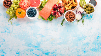 A set of healthy food. Fish, nuts, protein, berries, vegetables and fruits. On a white background. Top view. Free space for text.