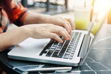 Hands typing on laptop