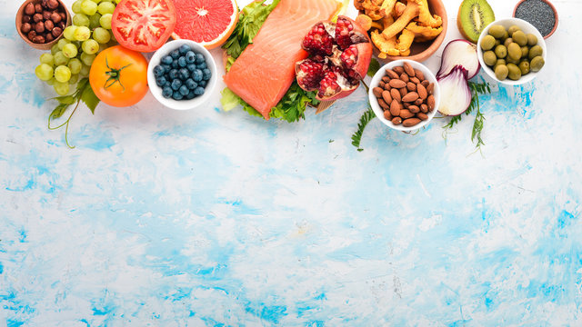 A Set Of Healthy Food. Fish, Nuts, Protein, Berries, Vegetables And Fruits. On A White Background. Top View. Free Space For Text.