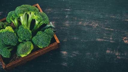 Broccoli in a Wooden box. Healthy food. On a wooden background. Top view. Copy space.