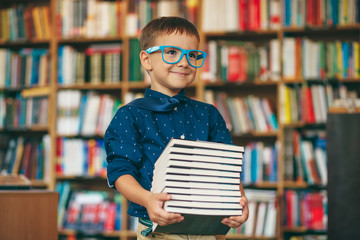 Boy with glasses and stack of books
