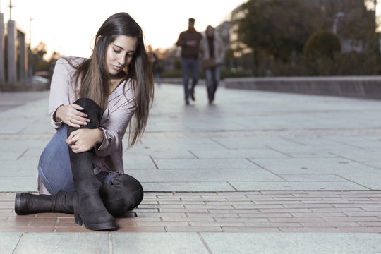 Beautiful girl in boots sitting on the floor.