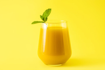 Mango Lassi dessert. Traditional Indian drink on yellow background. 