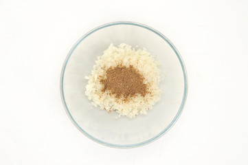 Chopped onions in a deep bowl. For spices added spices: black pepper, cumin, coriander. White background. Close-up. View from above.