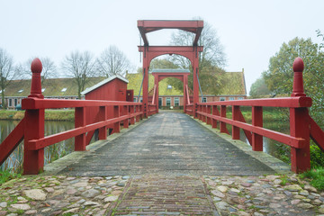 Fototapeta na wymiar The access bridge to Bourtange with on the left the access to an old fashioned toilet above the moat, a Dutch fortified village in the province of Groningen