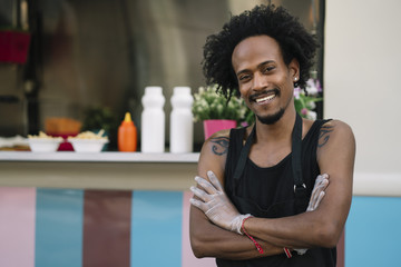 Portrait of a smiling food vendor with a food truk