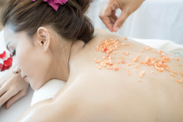 Obraz na płótnie Canvas Beautiful and healthy woman enjoying during a salt scrub back massage in spa salon