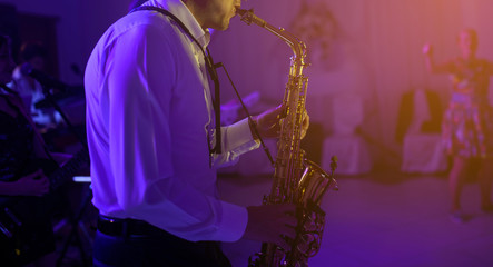 The saxophonist plaing at the party - obrazy, fototapety, plakaty