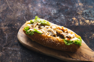 Long bread with mayonnaise on rustic background 