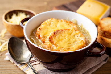 French onion soup with croutons and cheese on rustic wooden table