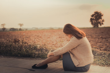 Portrait of lonely woman alone in a field. Vintage filter style.she heartbreak from love,sad girl concept on sunset vintage style