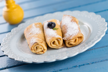 Three homemade rolled pancakes with blueberry
