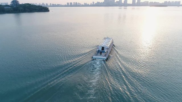 Aerial drone view of pleasure boat sails on the lake on sunset