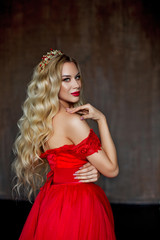 Charming princess in red dress, standing with his back