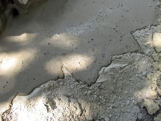 Fototapeta premium Gray simple building background - sand-cement mortar. Cement texture, half photo - liquid mud, half surface - dry mix