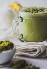BULLETPROOF MATCHA. Ketogenic keto diet hot drink. Tea matcha blended with coconut oil and butter. Cup of bulletproof matcha and ingredients on white background